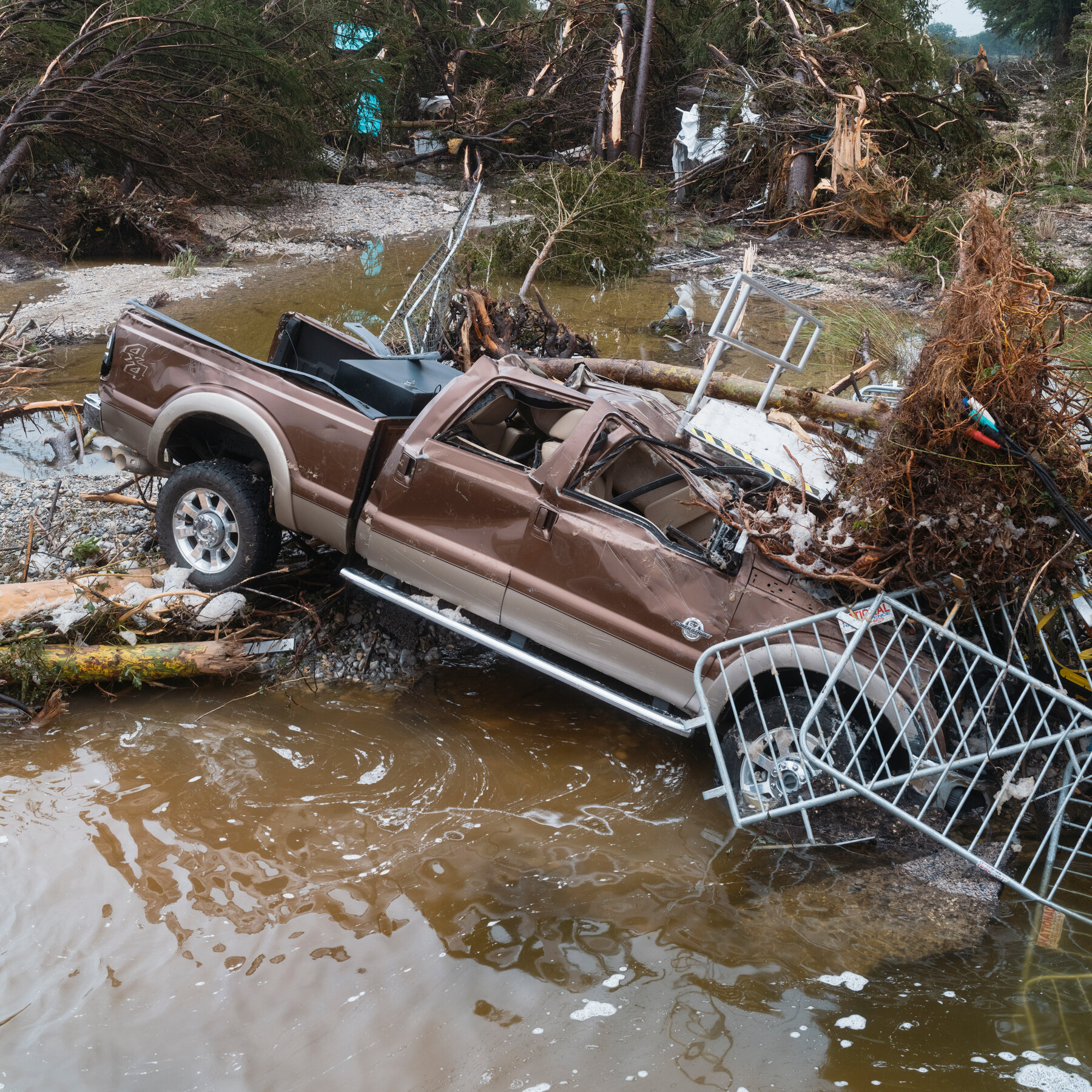Piles of debris and fast-moving water complicate rescue efforts along the Guadalupe River.