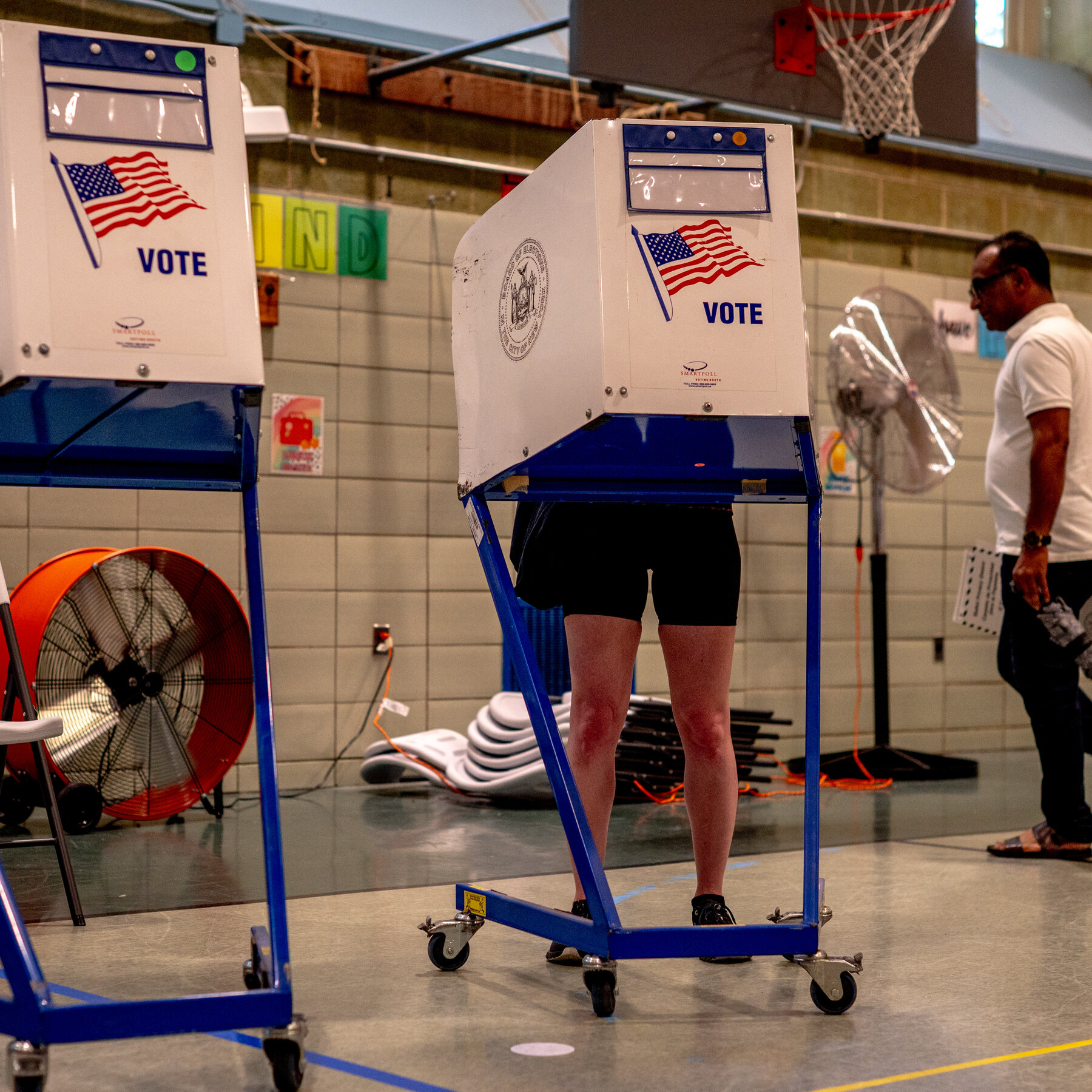 Using water and fans, N.Y.C. voters try to stay cool during primary voting.